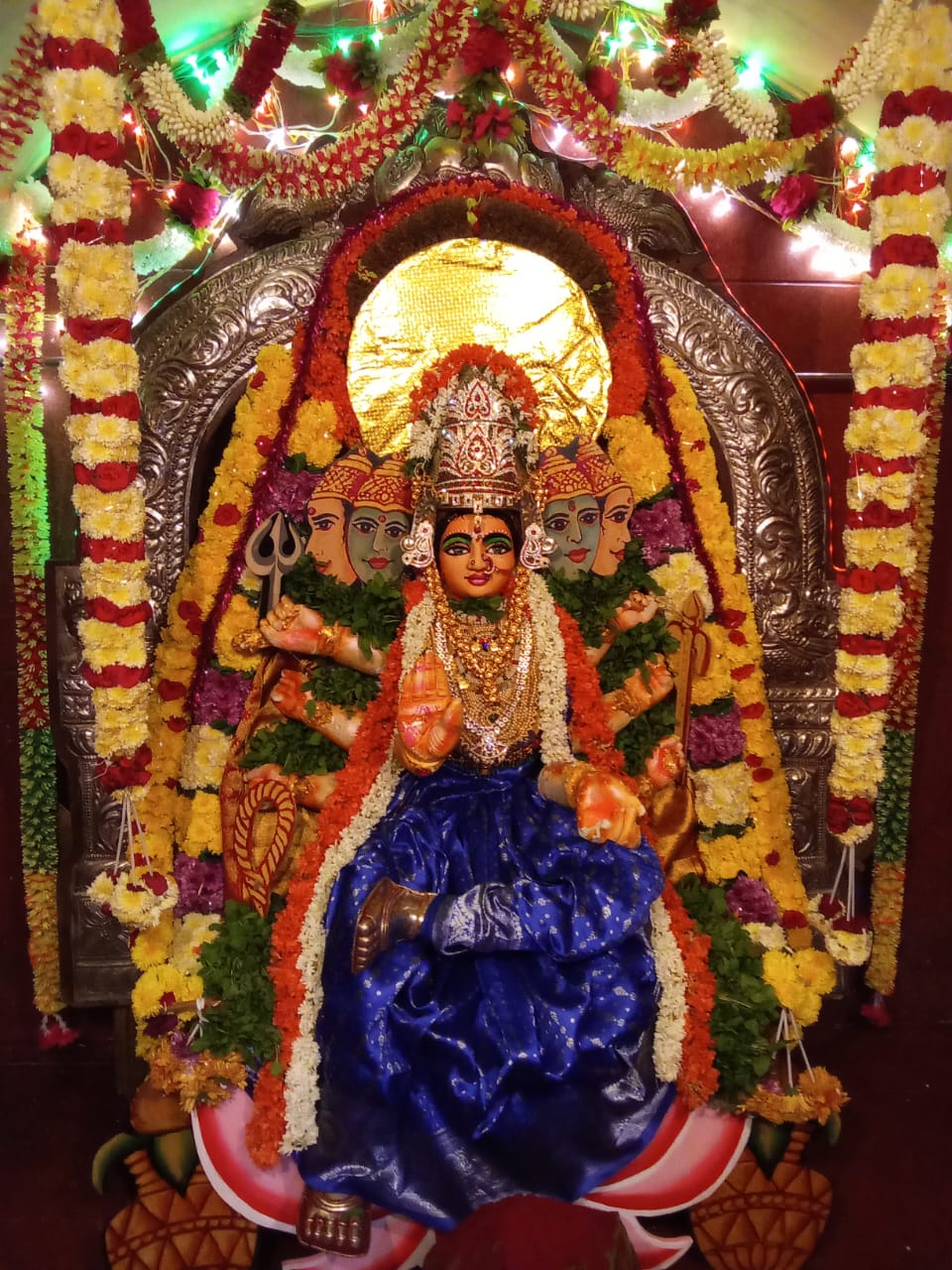 Temple celebration with decorated deity and devotees